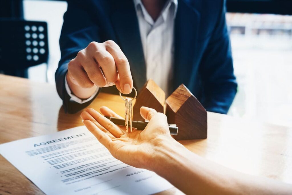 Real estate agents agree to buy a home and give keys to clients at their agency's offices.